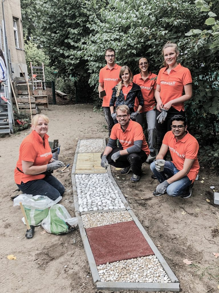 Sechs Contorion-Mitarbeiter in orangen Hemden präsentieren stolz ihr Werk
